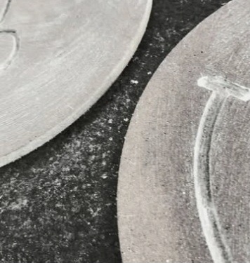 A carved disc at the workbench
